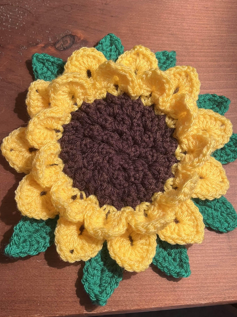 Crocheted sunflower on a wooden surface