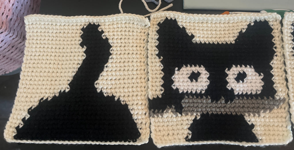 Black and white patterned crocheted fabric squares on a dark background