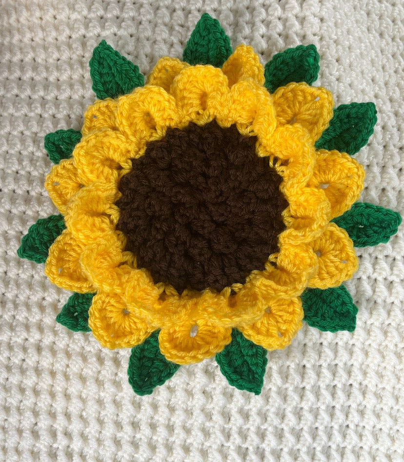 Crocheted sunflower on a textured fabric background